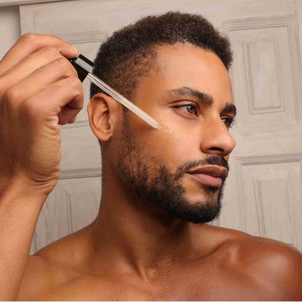 Hombre aplicando Skin Recovery Serum de Homo Naturals durante su rutina facial para ayudar a equilibrar la piel y mejorar su aspecto. Serum facial para hombres con fórmula natural y certificación ecológica, ideal para pieles sensibles y con tendencia acneica. Con prebitótico para restaurar pieles desequilibradas y enrojecidas.